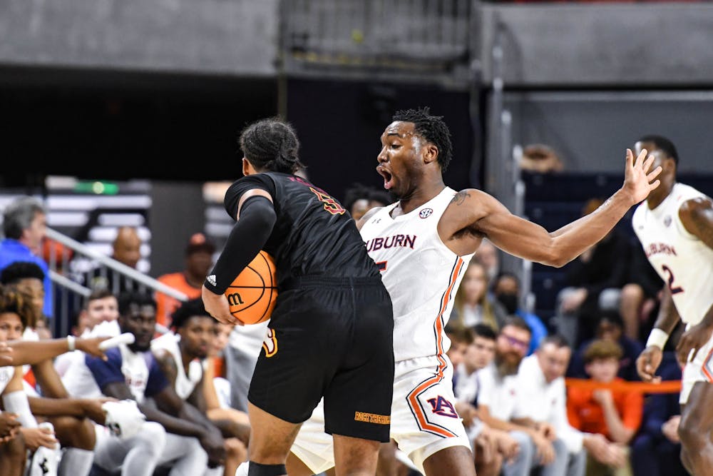 <p>Auburn center guard Chris Moore (5) draws contact from a Winthrop attacker in Neville Arena on Nov. 15, 2022.</p>