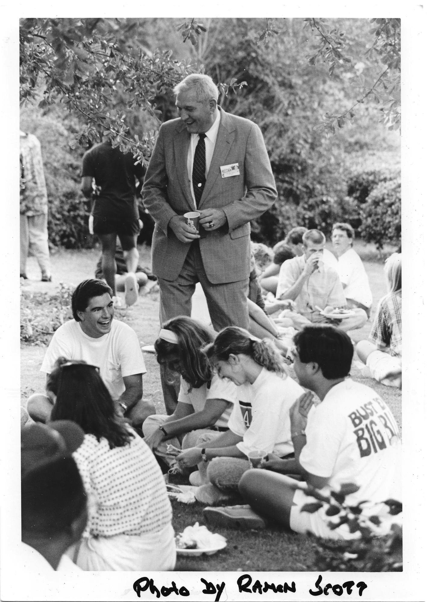 A group of students socializing with each other and a man in a suit. Archive photo. 