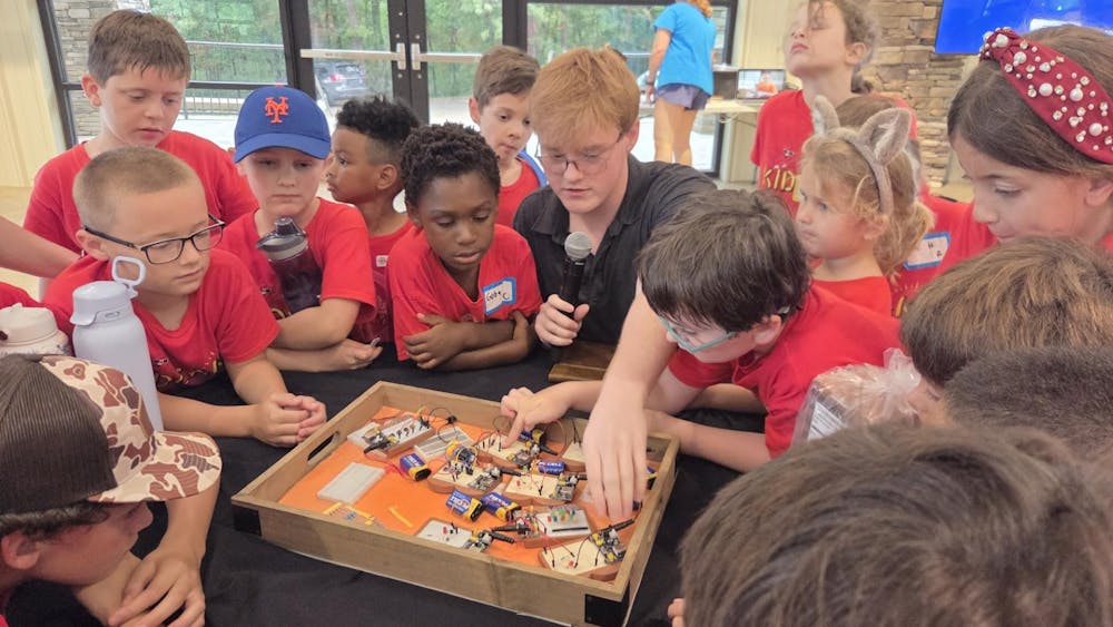 <p>Joseph Rusk shows a group of kids The Breadboard Company's electronics starter kit. | Contributed by Joseph Rusk.</p>