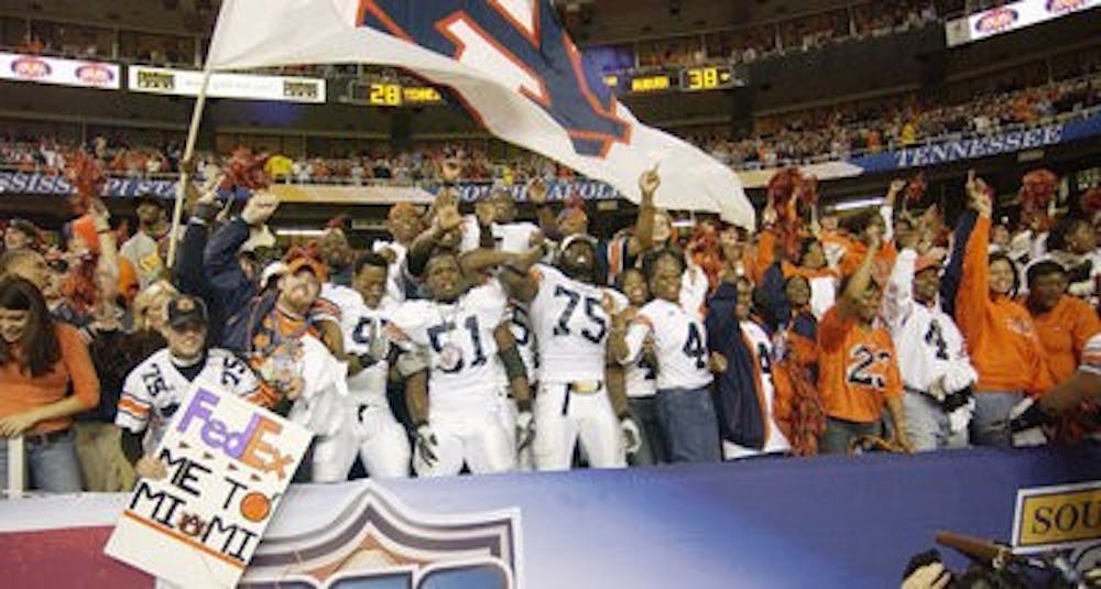 Auburn players celebrate with fans after winning the school's first conference championship game in 2004. (Todd Van Emst / Auburn Media Relations)