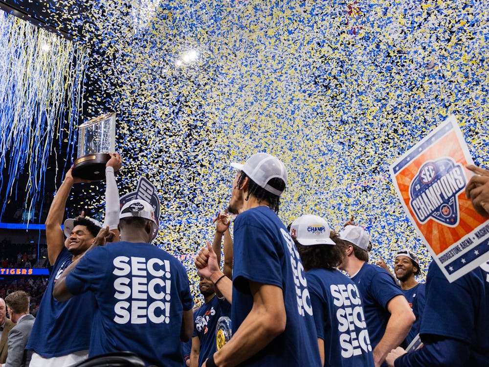Dylan Cardwell hoists the SEC Tournament trophy as the confetti begins to rain down on the Tigers on March 17, 2024