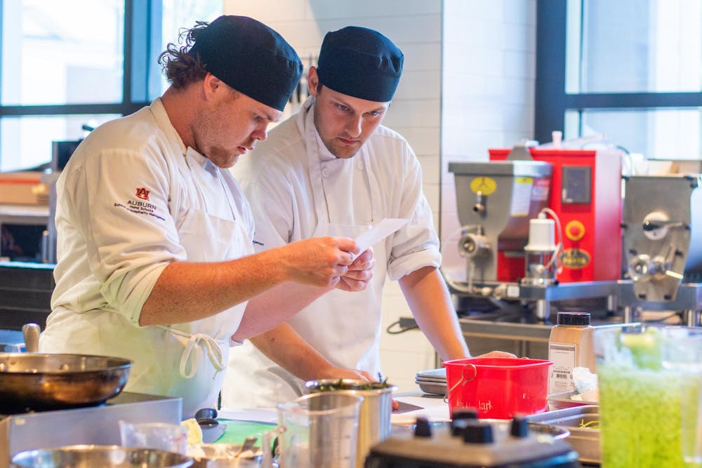 <p>Two lab students decipher cooking instructions at the Tony &amp; Libba Rane Culinary Science Center on Sept. 24, 2025.</p>