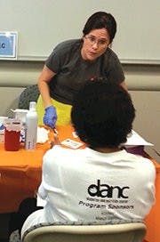 Lynne Hudson, EAMC DANC diabetes coordinators, helps a student.