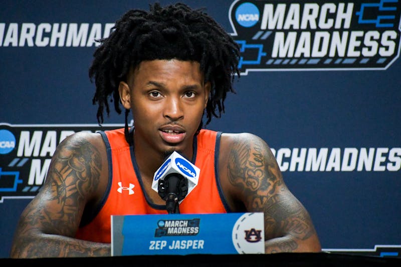 Zep Jasper (12) raises a brow while answering questions from reporters about Auburn's upcoming second-round game of the NCAA Tournament during a press session in Greenville, South Carolina, on March 19, 2022.