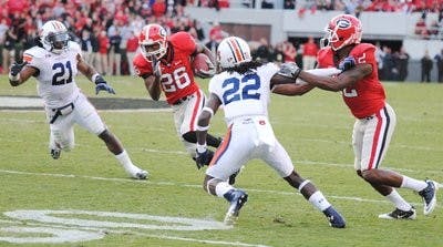Senior linebacker Eltoro Freeman and junior defensive back T'Sharvan Bell rush to bring down Georgia wide receiver Malcolm Mitchell in Athens Saturday. (Maria Iampietro / PHOTO EDITOR)