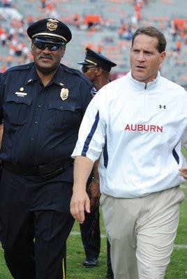 Melvin Owens escorts Gene Chizik off the field Saturday after Auburn's win over the Warhawks. Owens has been escorting coaches since 1983. (Maria Iampietro / Associate Photo Editor)