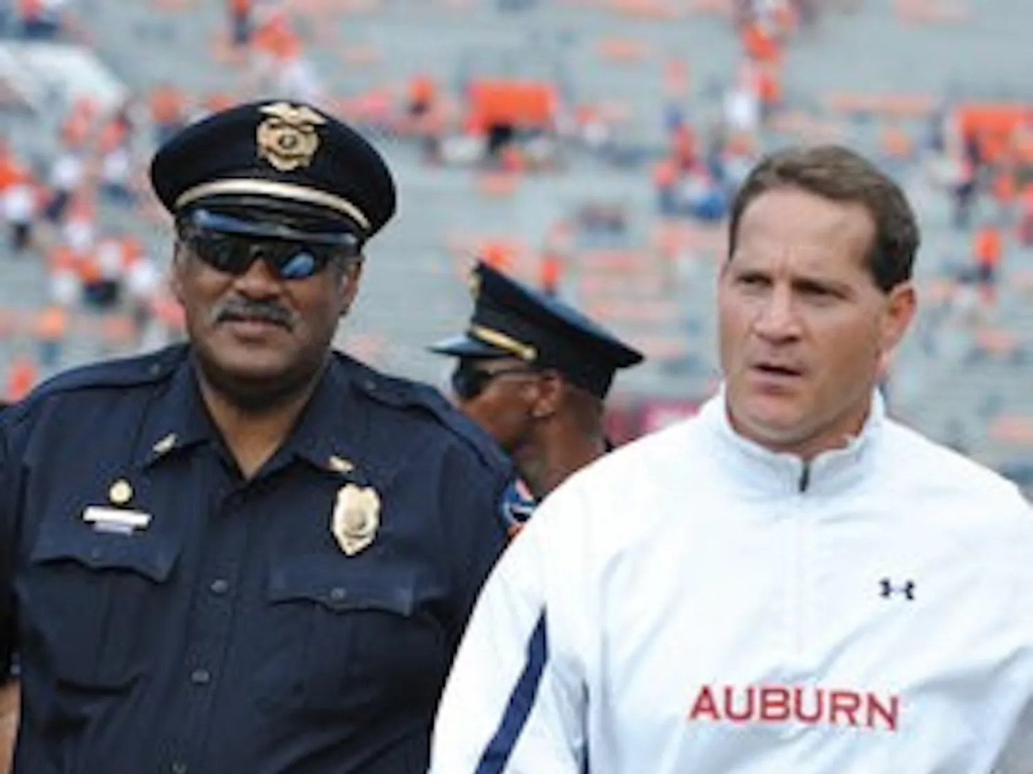 Melvin Owens escorts Gene Chizik off the field Saturday after Auburn's win over the Warhawks. Owens has been escorting coaches since 1983. (Maria Iampietro / Associate Photo Editor)