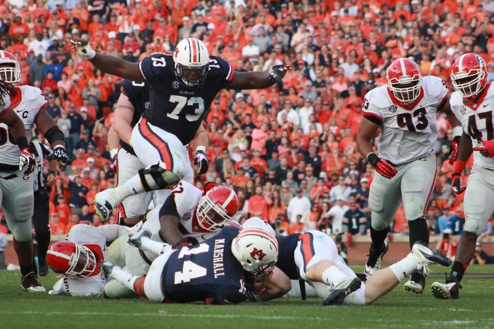 Greg Robinson jumps over a pile of football players during the game against the University of Georgia on November 16, 2013. (Jenna Burgess / ASSOCIATE PHOTO EDITOR)