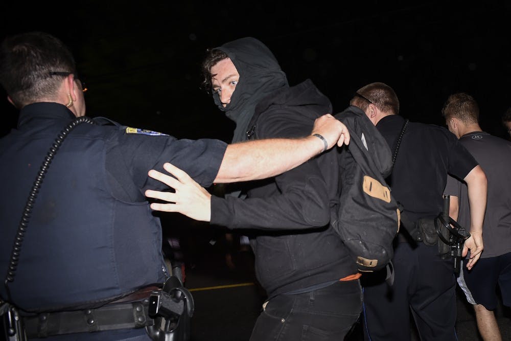 An Auburn police officer grabs an anti-fascist protester following an argument on Tuesday, April 18, 2017 in Auburn, Ala. 
