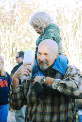 Kevin Tillman, 49, of Cullman, carries his grandson James Scott Lackey on his shoulders during Syrup Sopping Day Oct. 30. Both Syrup Sopping Day and the Historical Fair are geared toward families, featuring activities such as bungee jumping, rock climbing, chicken exhibits and pony rides.