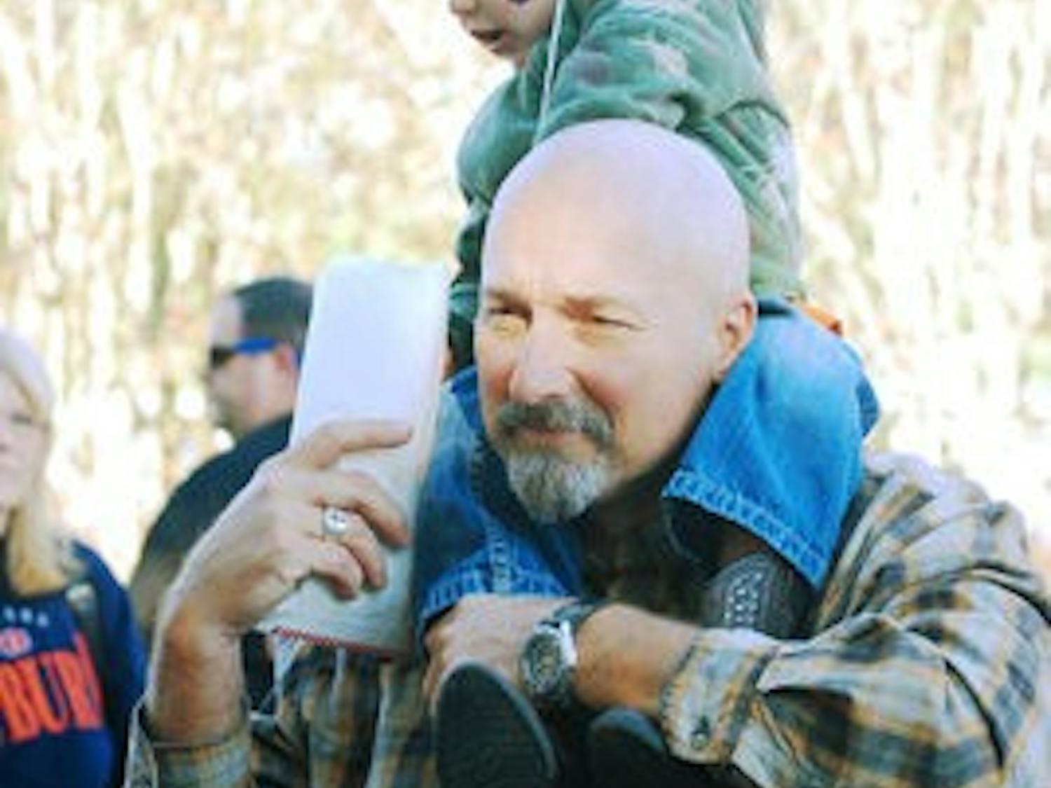 Kevin Tillman, 49, of Cullman, carries his grandson James Scott Lackey on his shoulders during Syrup Sopping Day Oct. 30. Both Syrup Sopping Day and the Historical Fair are geared toward families, featuring activities such as bungee jumping, rock climbing, chicken exhibits and pony rides.