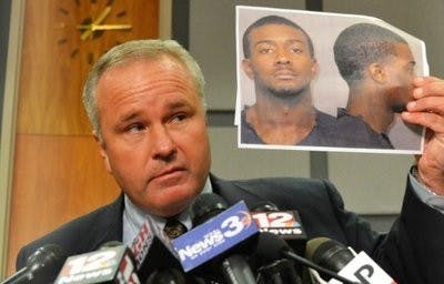 Former Police Chief Tommy Dawson holds up a picture of Desmonte Leonard.