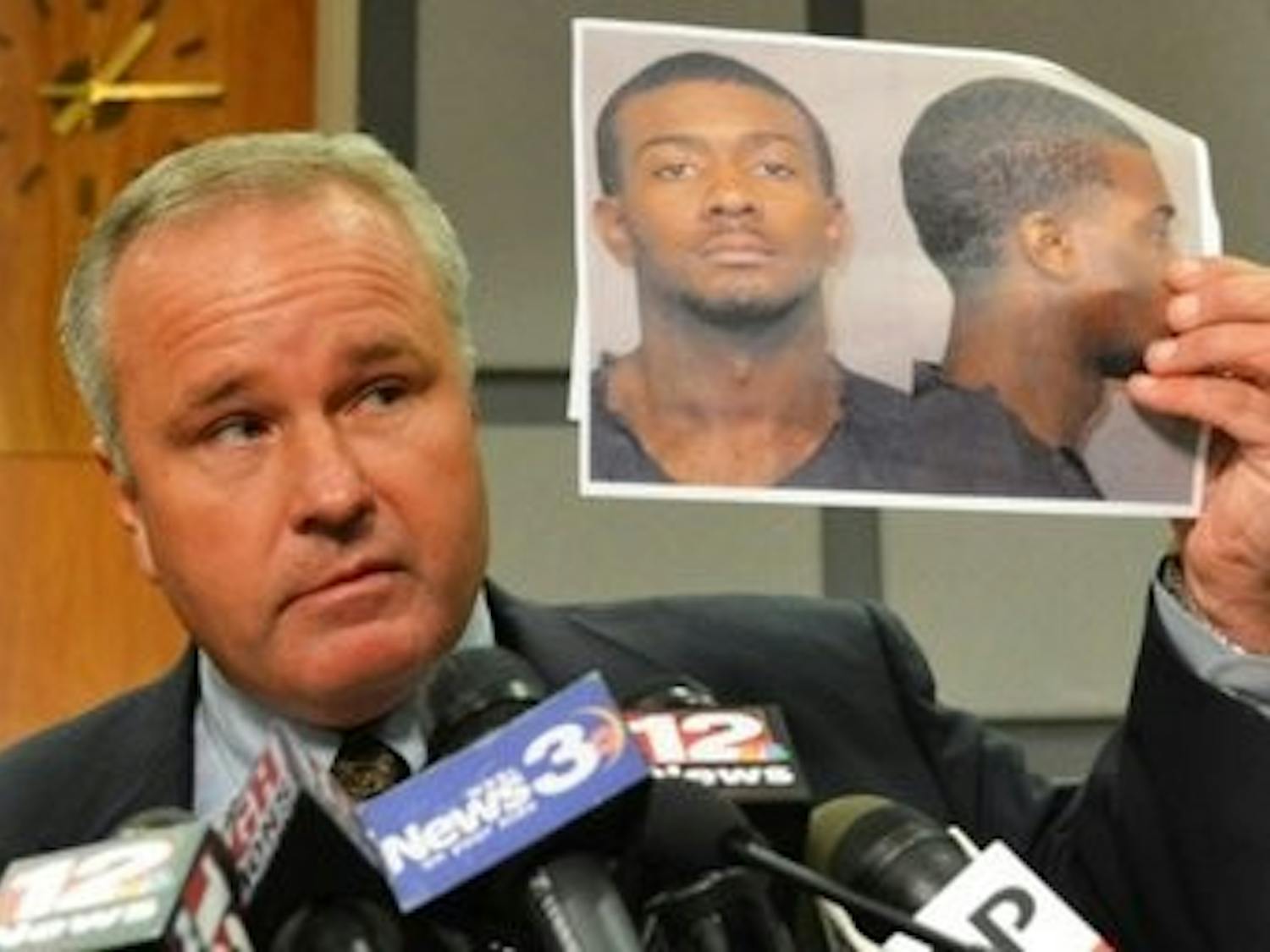 Former Police Chief Tommy Dawson holds up a picture of Desmonte Leonard.