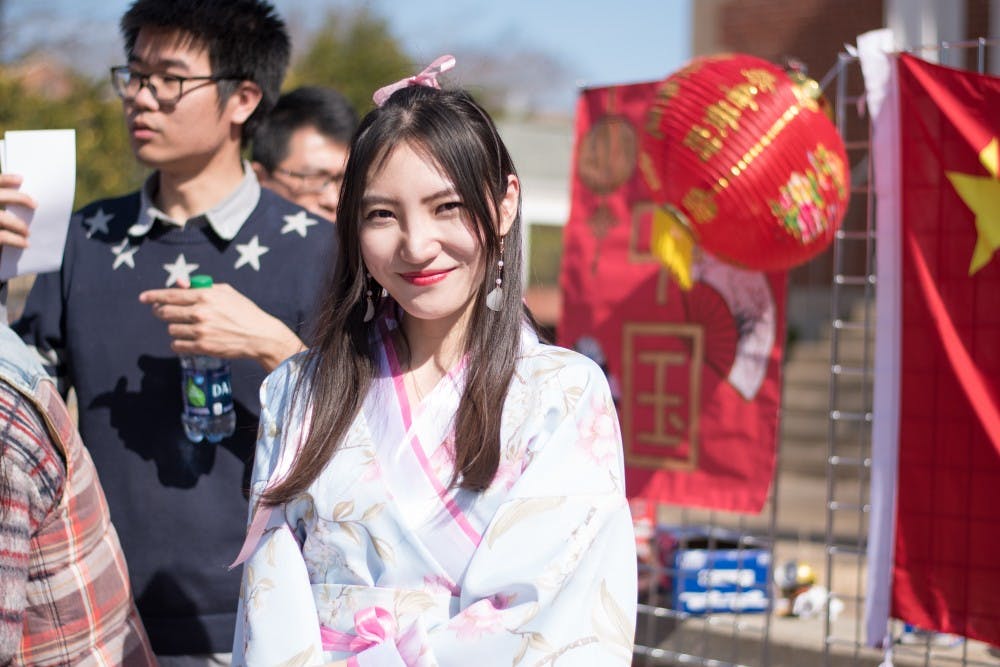 A Chinese student smiles by the table for China at the ISO World Fair on Tuesday, Feb. 6, 2018, in Auburn, Ala.