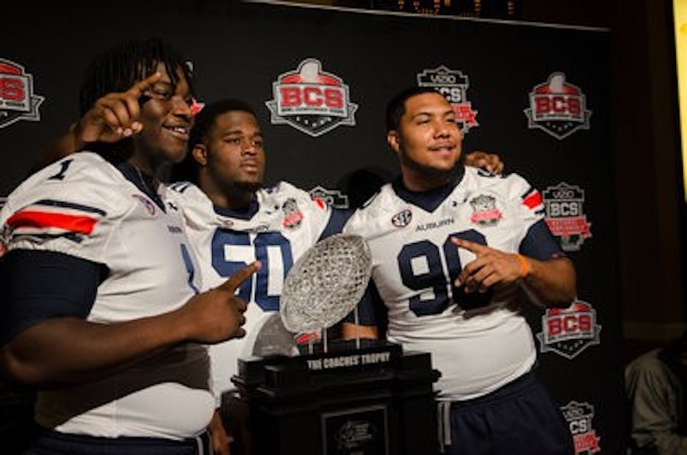 Defensive lineman Montravius Adams, Ben Bradley and Gabe Wright pose with the BCS Coaches' Trophy. (Raye May / DESIGN EDITOR)