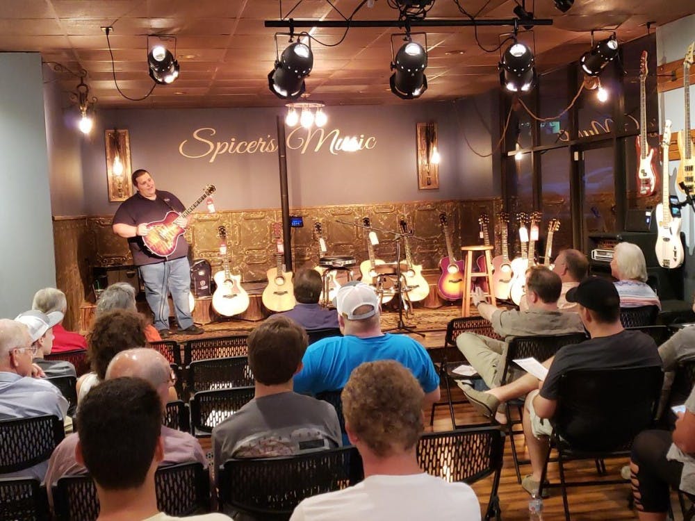 <p>Visitors learning how to best choose a guitar</p>