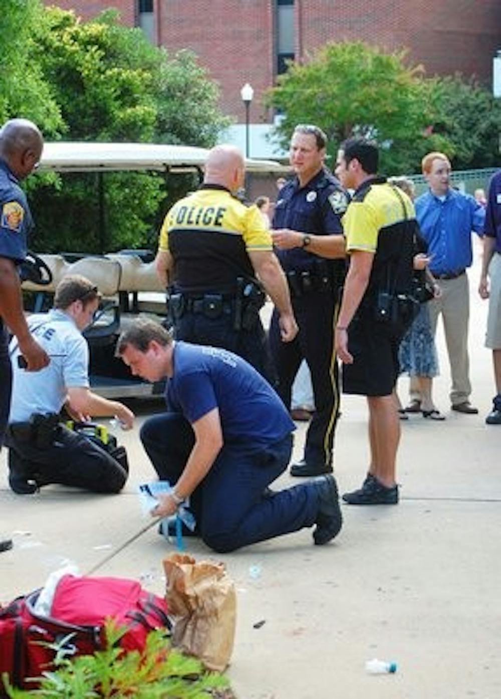 Auburn police officers and EMT personnel clean up materials in front of Little Hall where a man collapsed on Monday afternoon. (Derek Lacey / ASSOCIATE CAMPUS EDITOR)