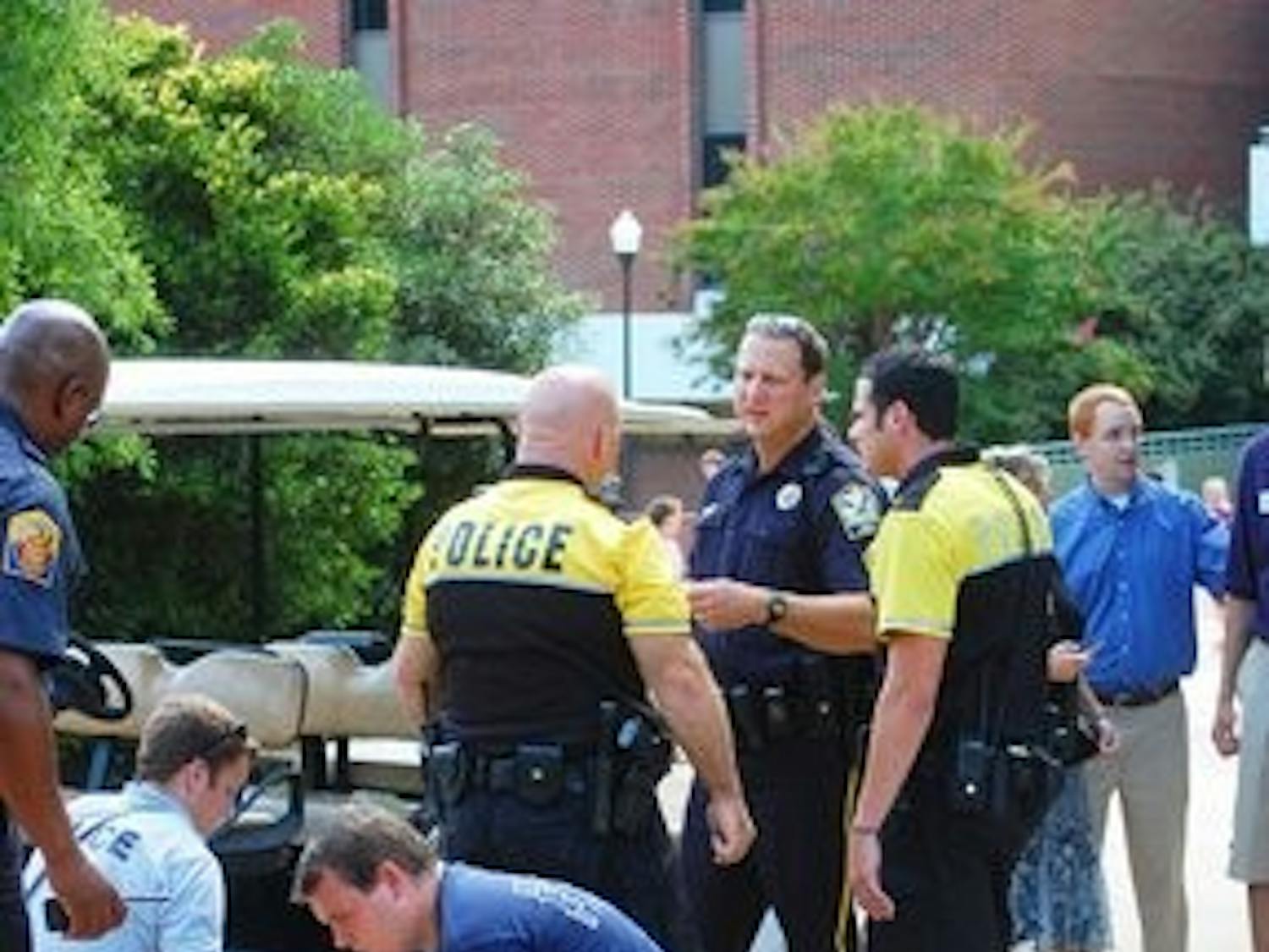 Auburn police officers and EMT personnel clean up materials in front of Little Hall where a man collapsed on Monday afternoon. (Derek Lacey / ASSOCIATE CAMPUS EDITOR)