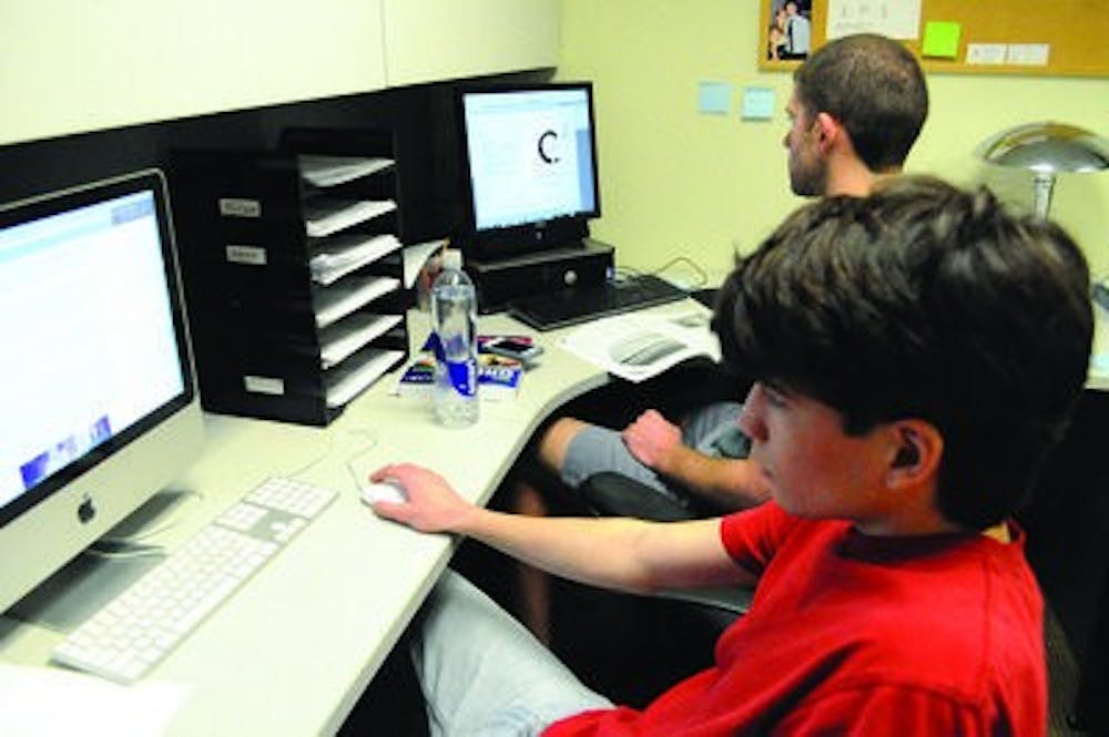 Cove Headley, front, copy editor for the AU Circle, and Zack Fritz, editor-in-chief, prepare the magazine's latest issue. (Christen Harned / ASSISTANT PHOTO EDITOR)