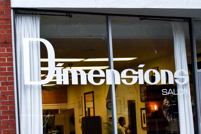 The Dimensions Salon's main window as seen from E. Magnolia Avenue in Auburn, Alabama, on April 18, 2022.