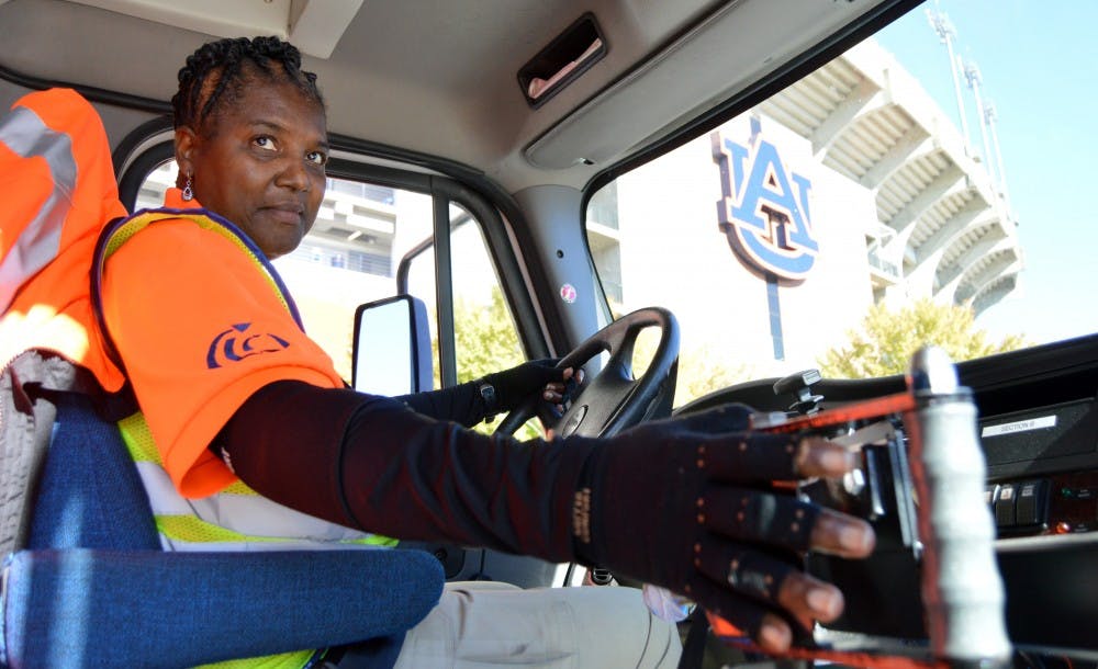<p>Nettie Chambers, Tiger Transit driver, opens doors for students to board bus.</p>