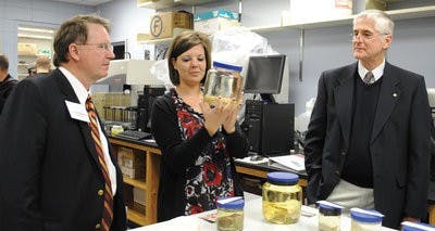 Alexis Janosik, Ph.D. student in marine biology, shows visitors marine creatures in jars in the new climate change laboratory. (Maria Iampietro / Assistant Photo Editor)