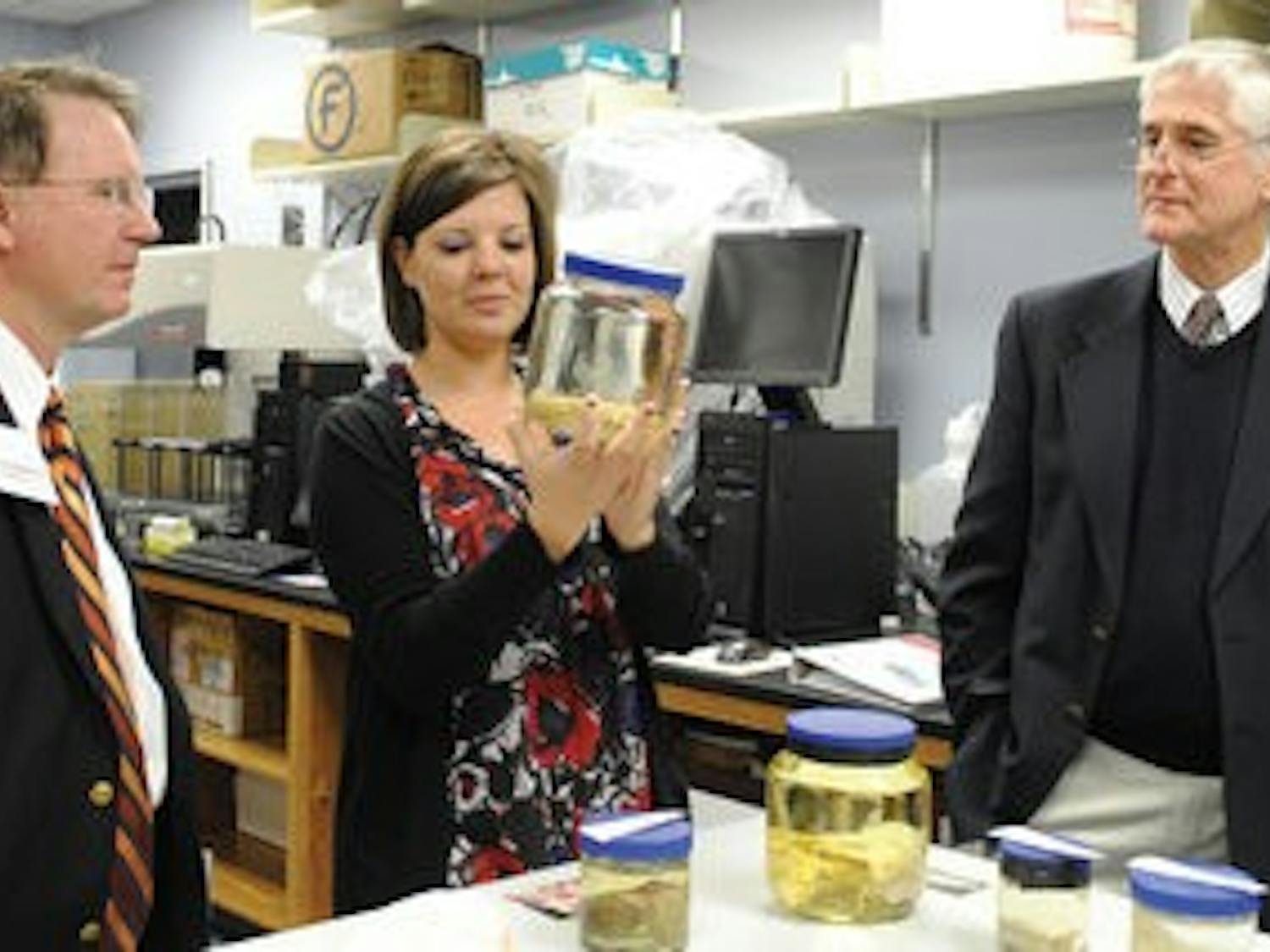 Alexis Janosik, Ph.D. student in marine biology, shows visitors marine creatures in jars in the new climate change laboratory. (Maria Iampietro / Assistant Photo Editor)