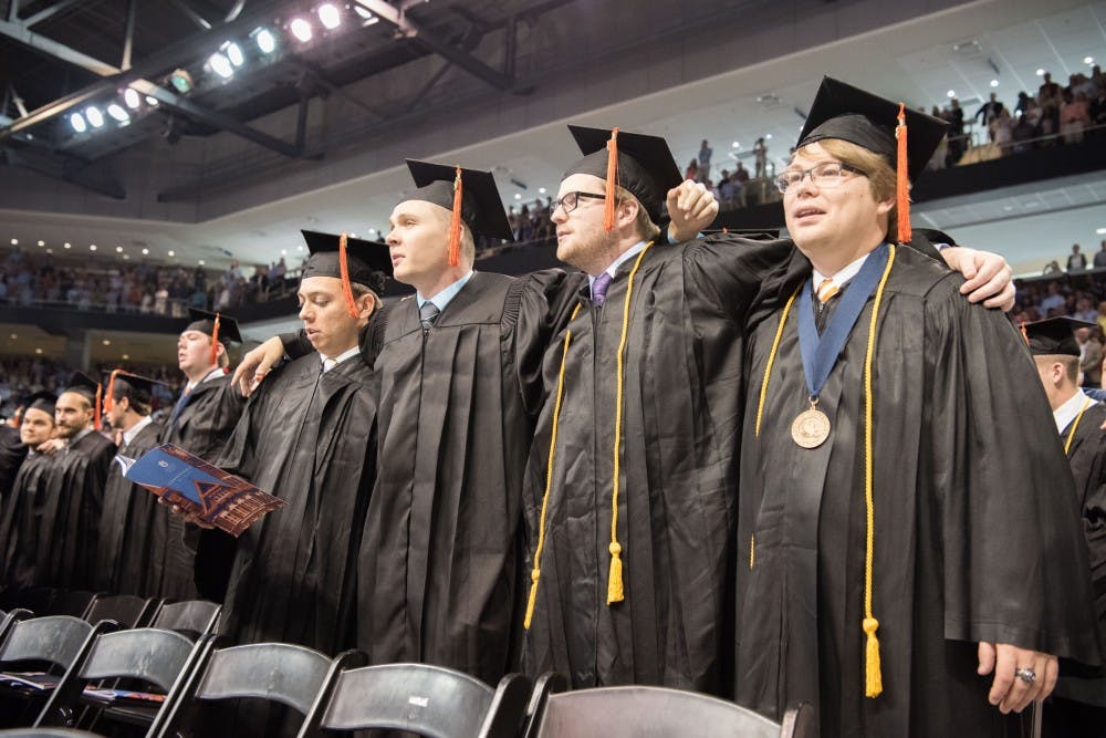 <p>Graduates link arms and sing the Alma Mater&nbsp;during Auburn University commencement exercises in Auburn Arena in Auburn, Ala., on Saturday, May 5, 2018.</p>