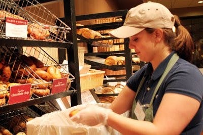 Holli Renfore, employee at Panera, places leftover food into boxes that will be shipped to the East Alabama Food Bank. (Alex Sager / Photo Editor)