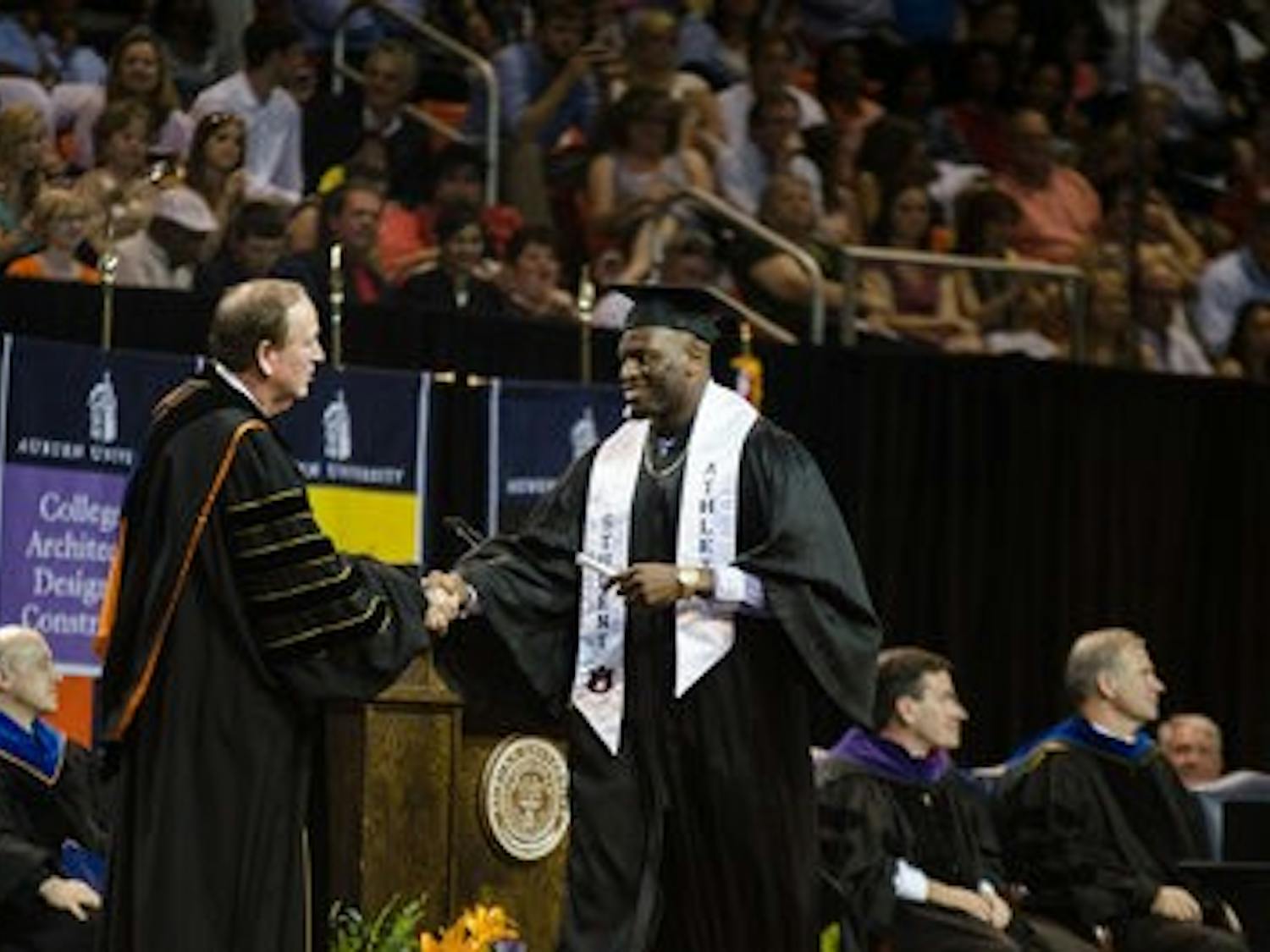 Defensive lineman LaDarius Owens, No.10, is handed his degree by Jay Gogue. \0x200B