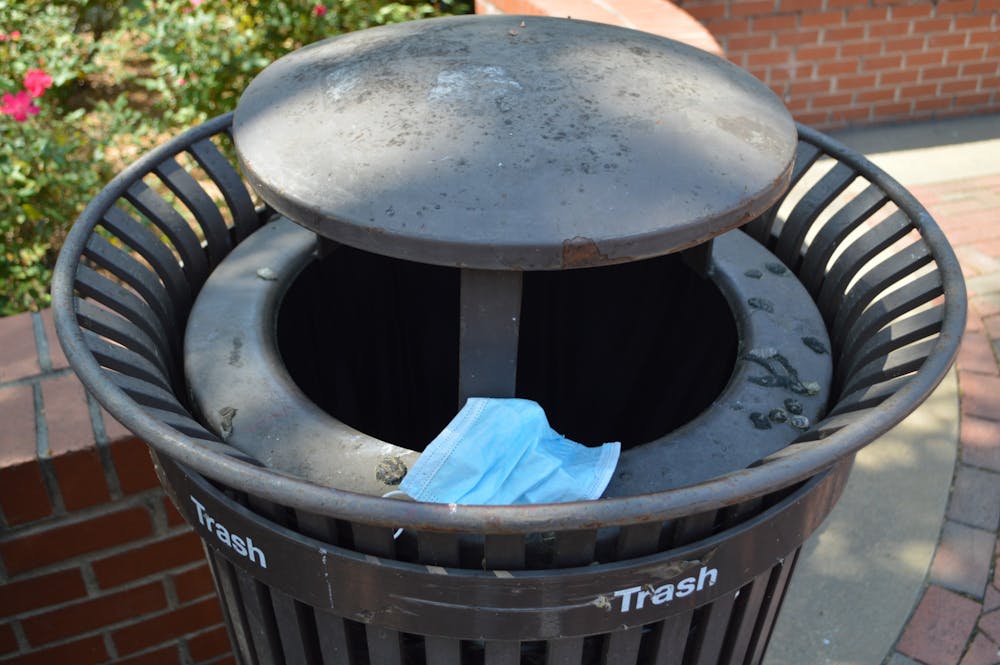 Mask pictured in a trash can on Auburn Universities campus on Apr. 7, 2021, in Auburn, Ala.