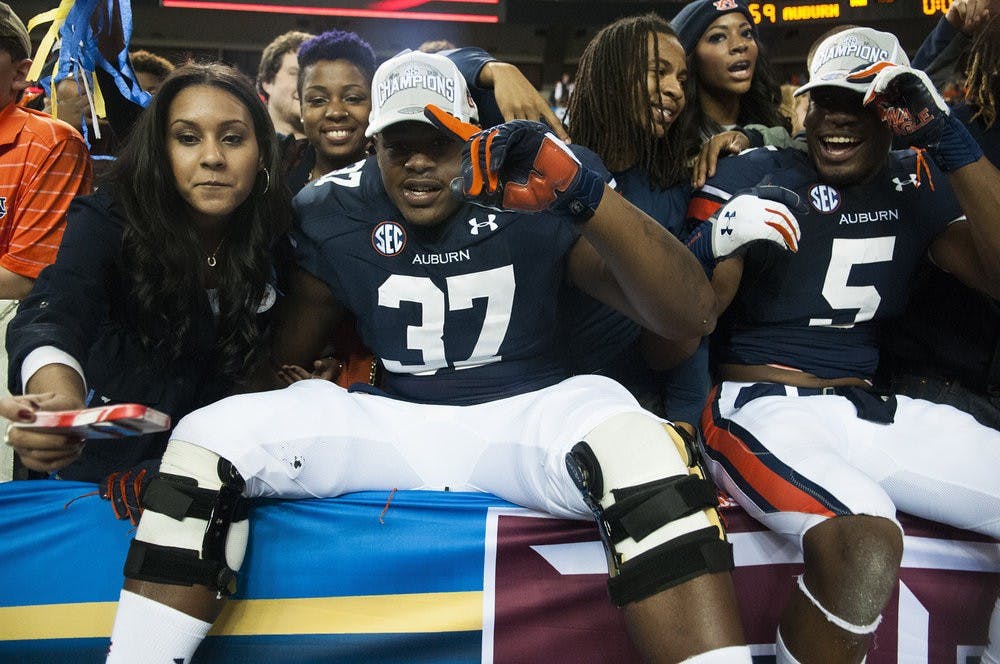 <p>Auburn defensive back Kamryn Melton (37) and Auburn wide receiver Ricardo Louis (5) celebrate with fans, Dec. 7, 2013. (File photo)</p>