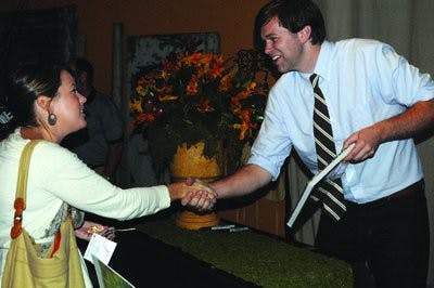 Auburn graduate James Farmer meets Leigh Hardy at his book signing for "A Time to Plant" Friday at Frou Frou floral shop. (Christen Harned / ASSISTANT PHOTO EDITOR)