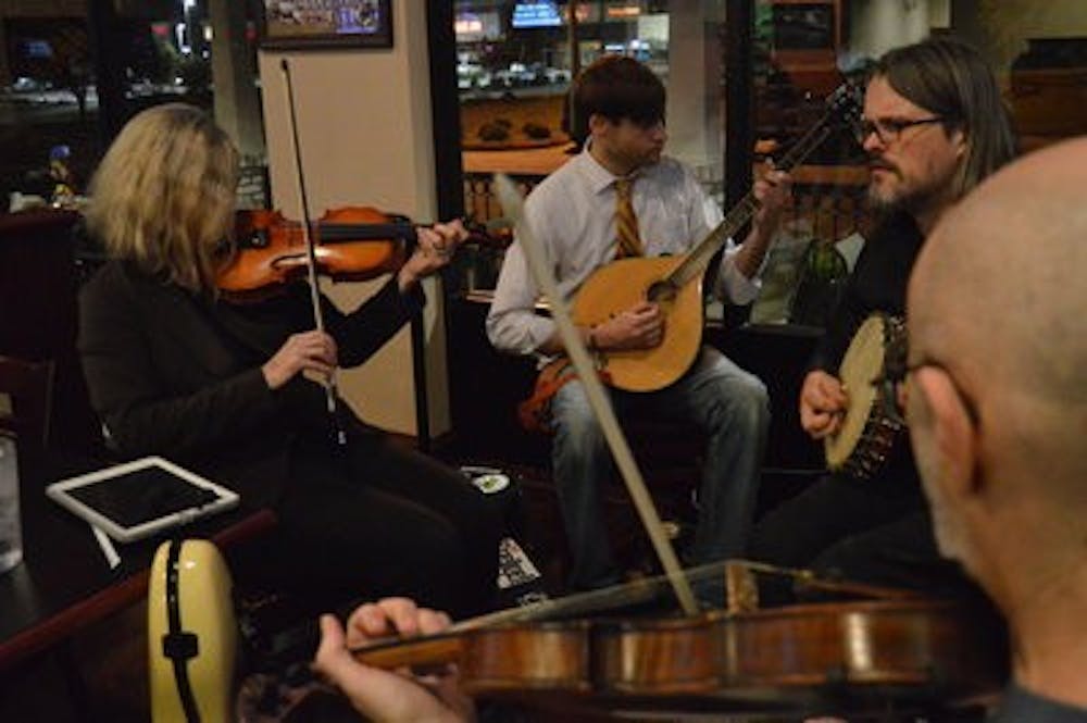 LEFT TO RIGHT: Dane Hite plays fiddle, Scott Miller plays Irish Bouzouki and Ralph Kingston plays banjo and tin whistle. (EMILY ENFINGER / ASSISTANT PHOTO EDITOR)