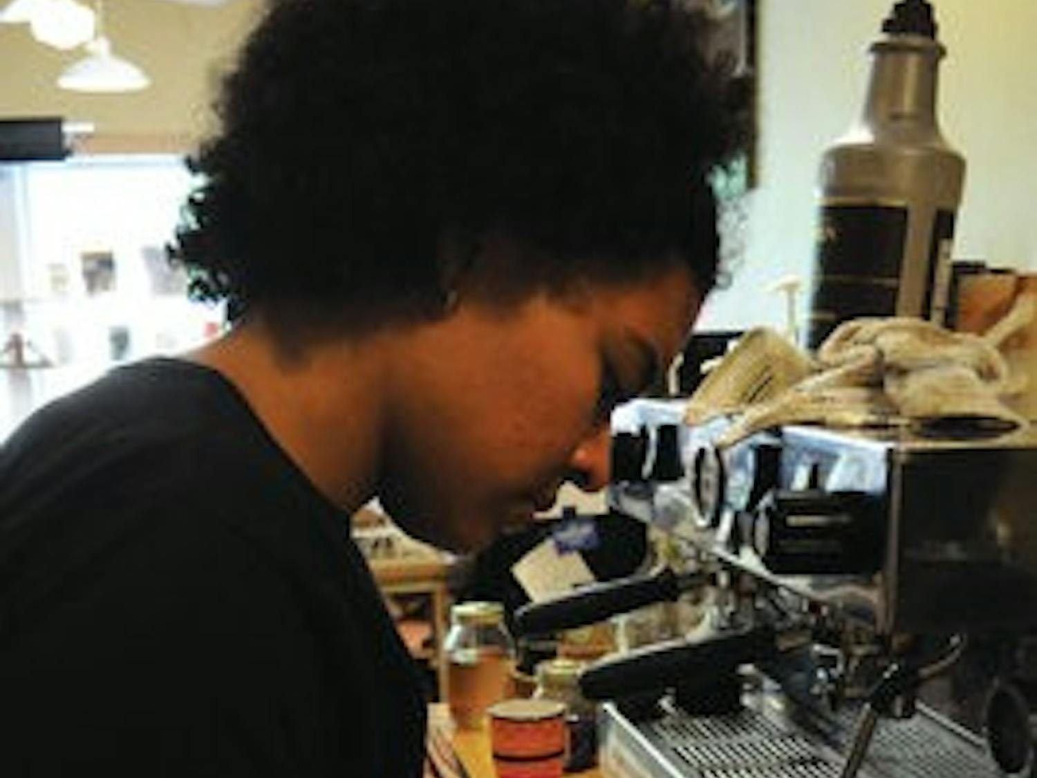 Alyssa Carodine, junior in anthropology and barista at Gnu's Room, makes a drink with latte art. (Christen Harned / ASSOCIATE PHOTO)