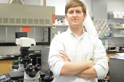 Christopher Easley stands in one of the chemistry labs where he does his research. (Christen Harned / Assistant Photo Editor)