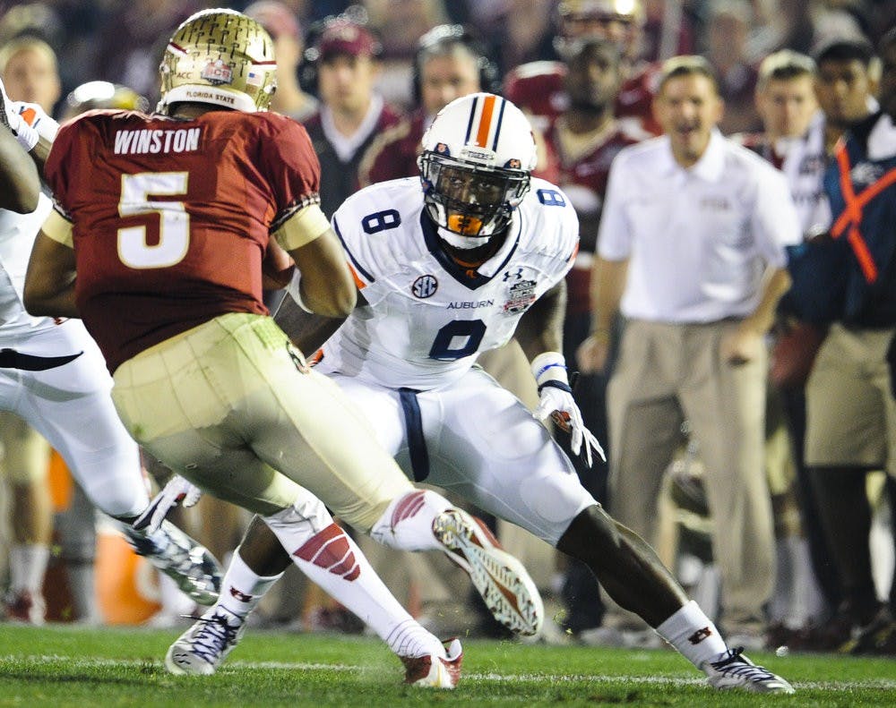 Auburn linebacker Cassanova McKinzy (#8) attempts to tackle Florida State quarterback Jameis Winston in the 2014 BCS National Championship Game. McKinzy is up for the Chuck Bednarik Award and the Bronko Nagurski Trophy. (Zach Bland / Assistant Photo Editor)