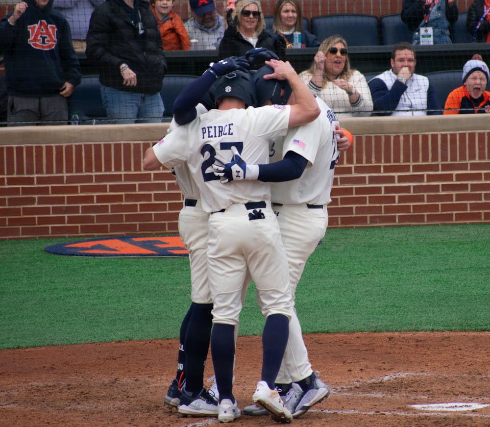 Bobby Peirce, Cooper McMurray, and Cooper Weiss celebrating on home plate after McMurray's home run in the game against Eastern Kentucky on Feb 17, 2024. 