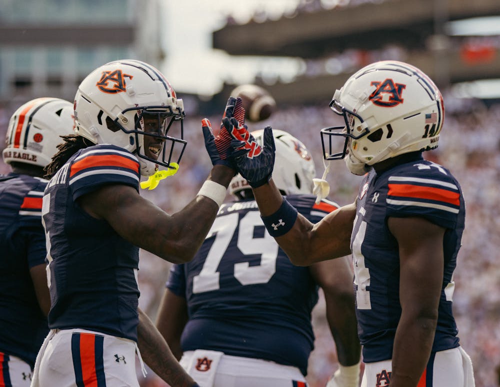 <p>Auburn football players celebrate a touchdown.</p>