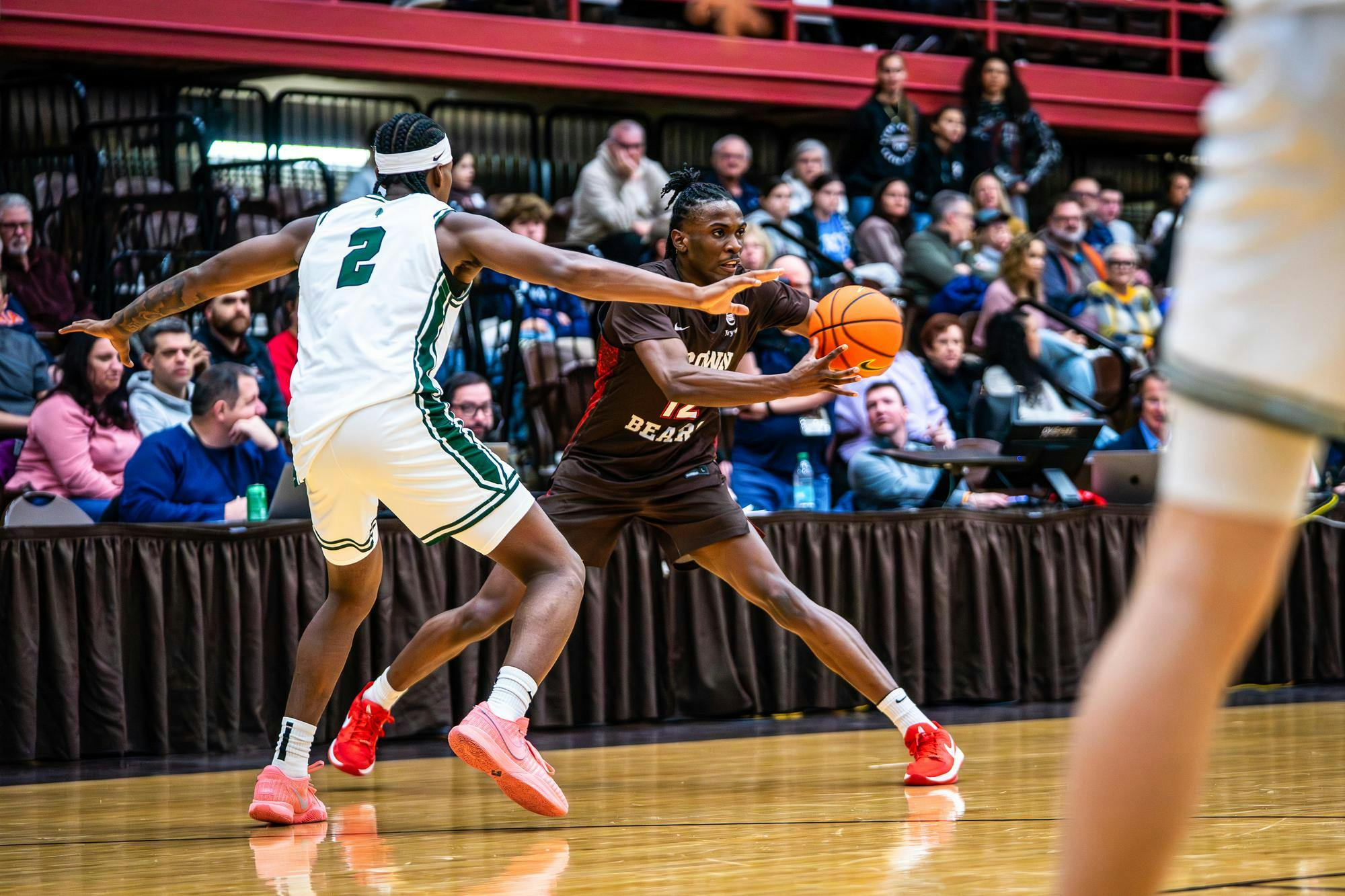 Photographed action shot from Brown v. Dartmouth men’s basketball game. Brown has the ball while being guarded by a Dartmouth player.