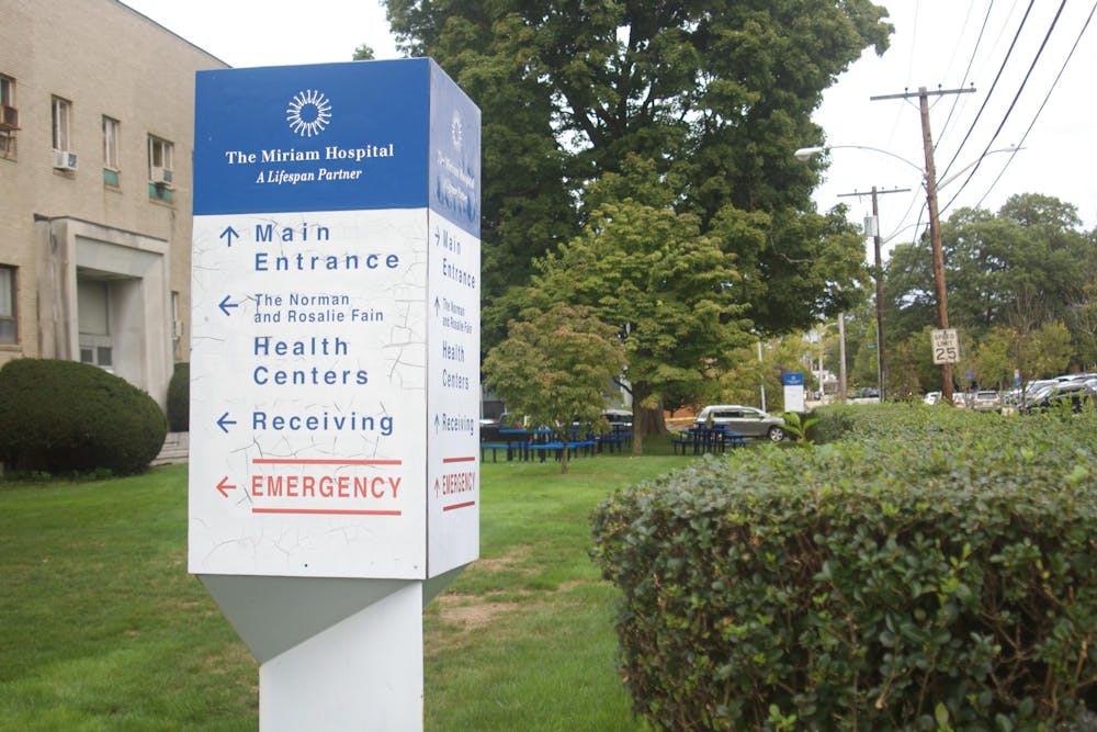 Photo of the directions sign for The Miriam Hospital. There is green grass in the background. 
