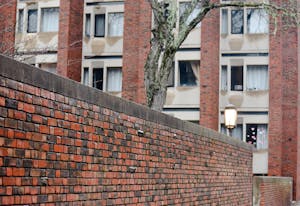 Brown's Graduate Center. A lit lantern and a lichen-covered tree stand outside.