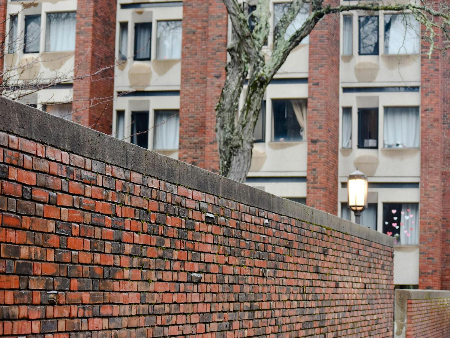Brown's Graduate Center. A lit lantern and a lichen-covered tree stand outside.