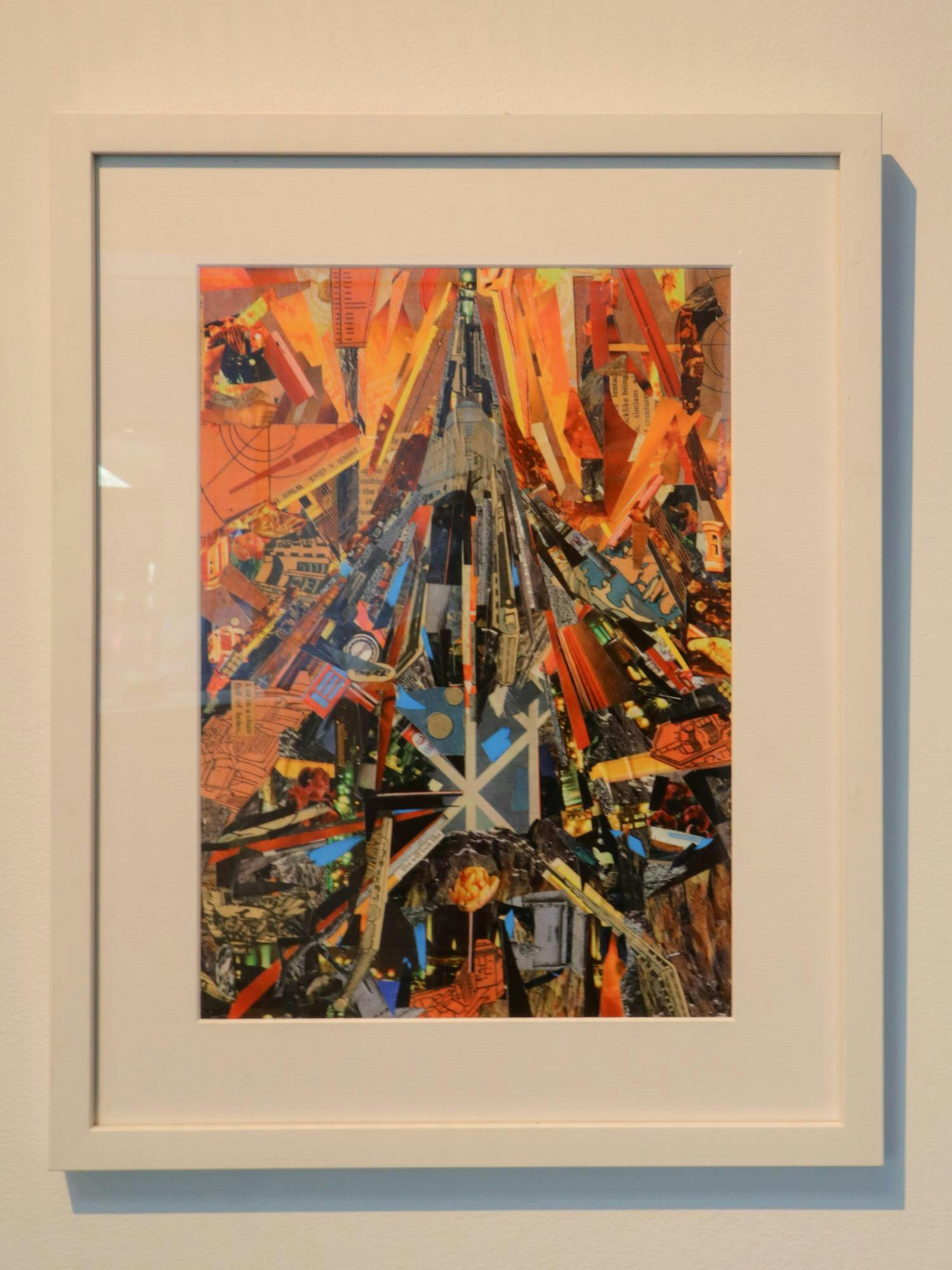 Photo of a framed multicolored, primarily orange, collage.