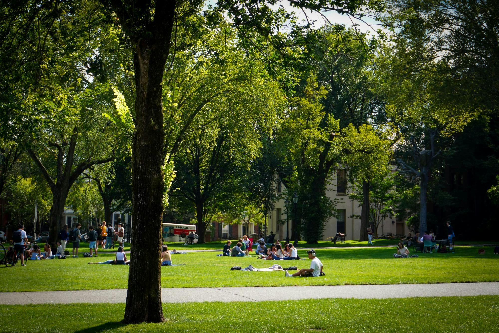 Photo of groups of students sitting on the Main Green at Brown University. 