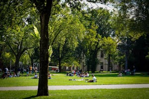 Photo of groups of students sitting on the Main Green at Brown University. 