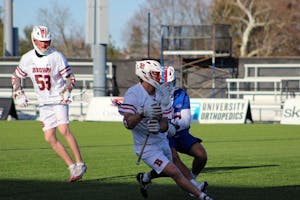 Photo of a Brown lacrosse player running.

