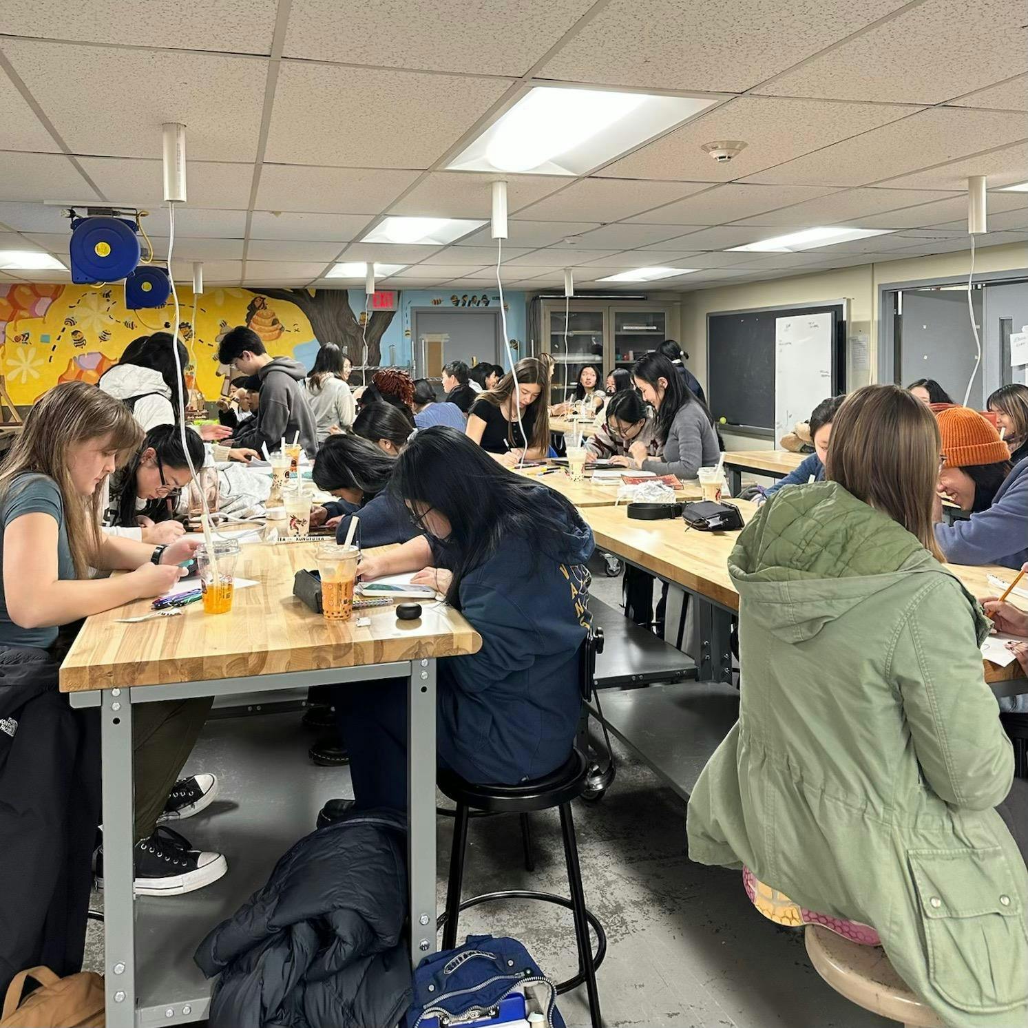 Photo of a classroom of students writing notes for dining hall workers. 