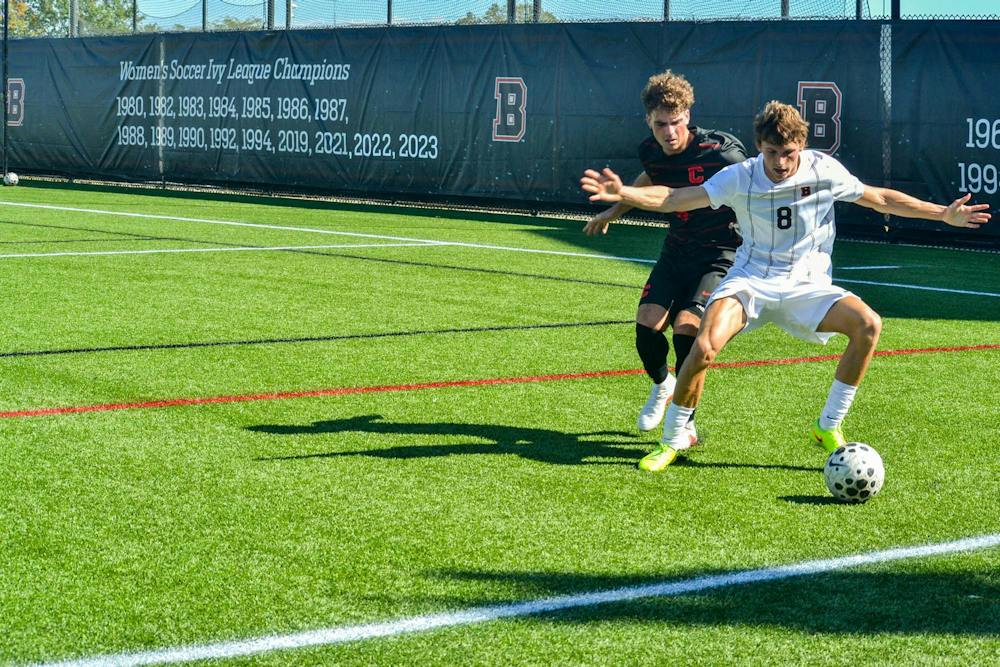 A photo of No. 8 James Snaith defending the ball from a Cornell player.

