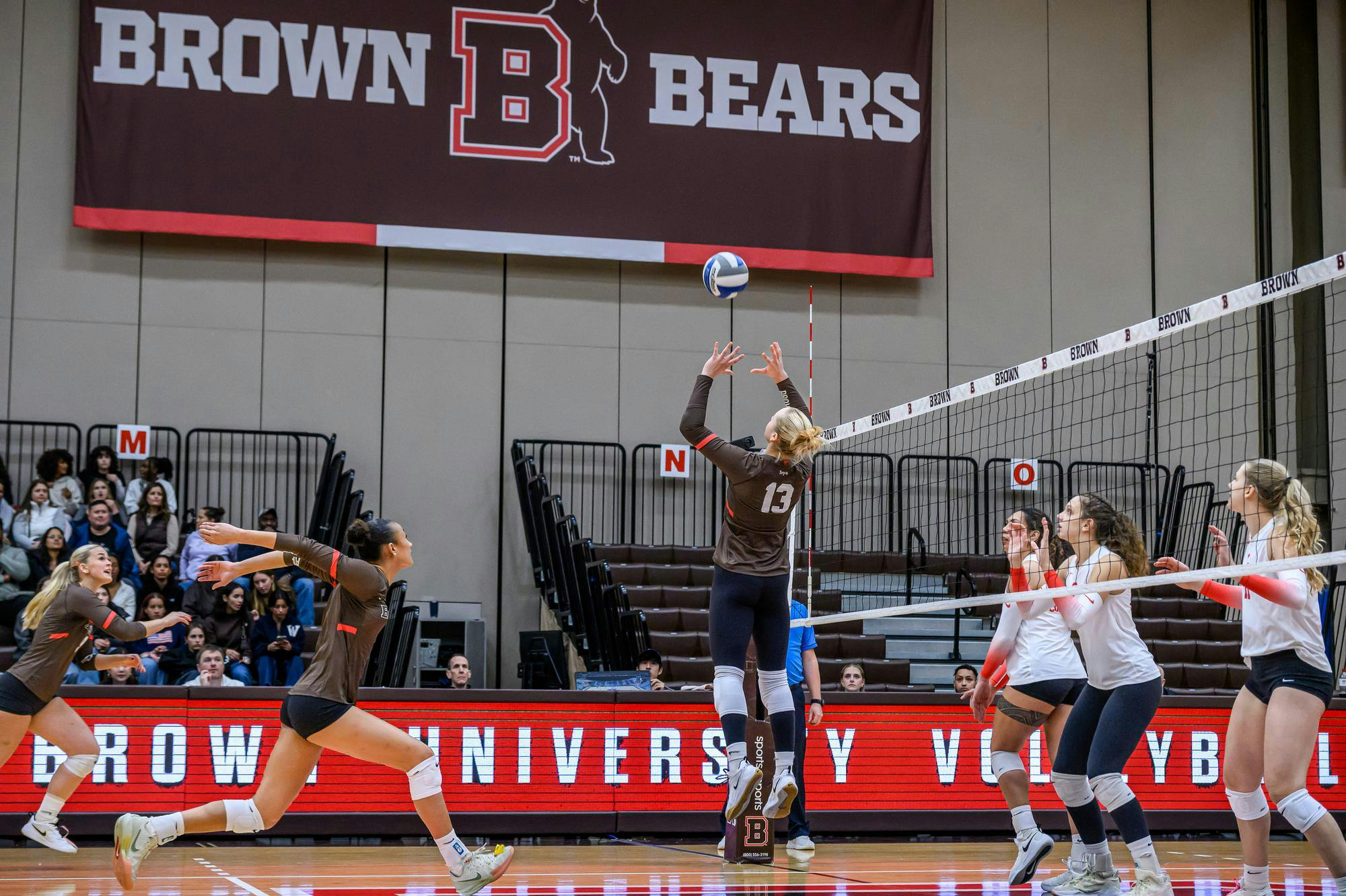 Photo of Julia Kakkis ’28 setting the ball high in the attack for a spike against Cornell.